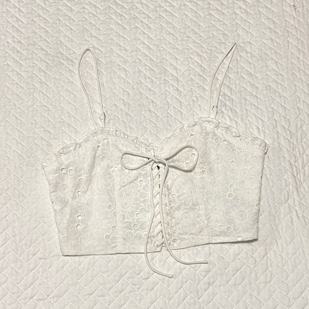 Lace up white crop top with flower details.